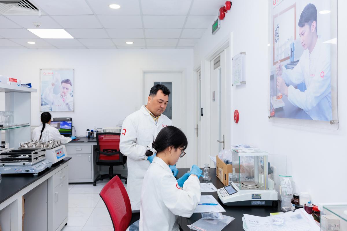 QIMA lab technicians perform chemical and physical testing at an accredited laboratory, supporting compliance programs for consumer products across global markets.